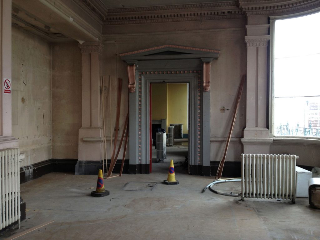 Building under renovation, slightly less peeling paint and a radiator and two cones in the middle of the floor as the regeneration progresses.