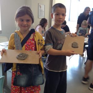 Children show off their clay artwork