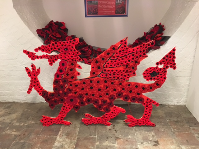 Image shows red Welsh dragon made out of poppies.=