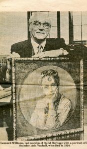 image shows man in business suit holding a portrait of Ada Vachell