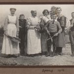 Adults and children in the countryside posing with cleaning utensils