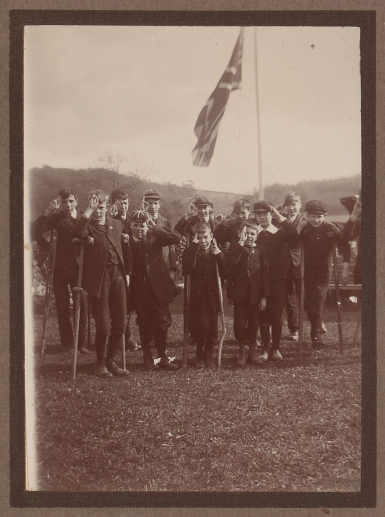 Boys in scout group stand in front of a union jack