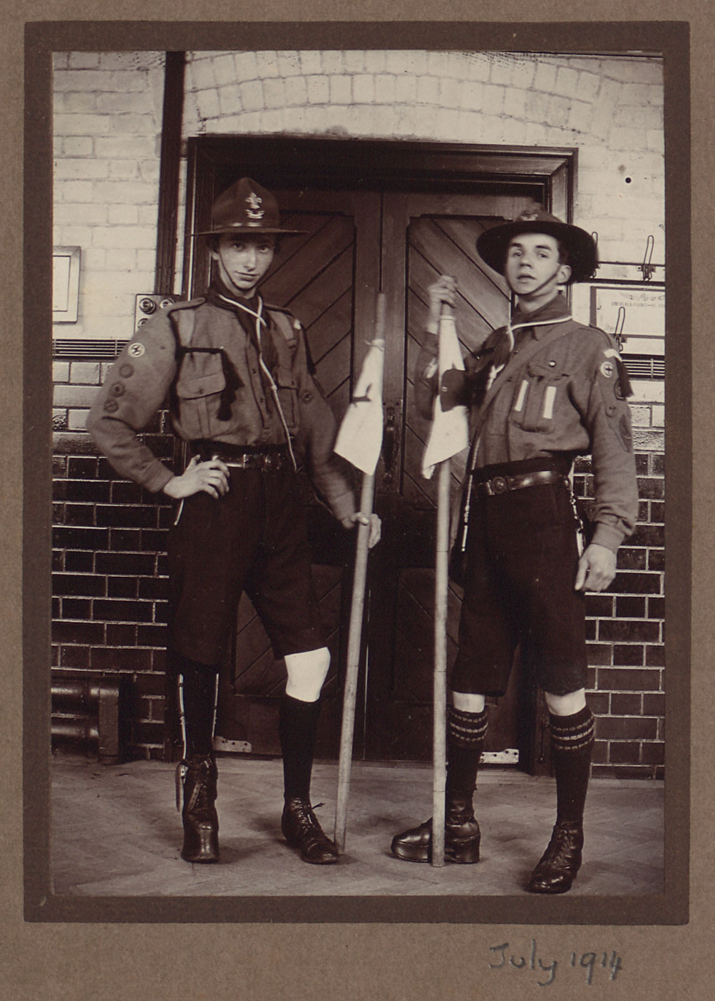 Two young men with scout uniforms and flags