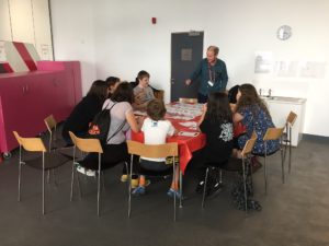 Participants are seated around a table sharing ideas in a group conversation