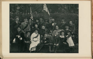older guild members in front of a hedge in a garden