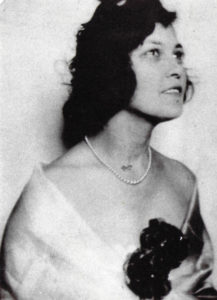 Woman with dark hair in a necklace and ballgown